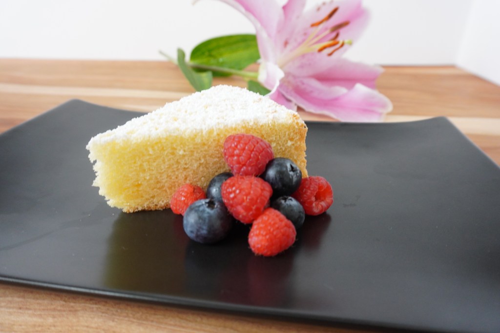 A slice of light and fluffy chiffon cake garnished with fresh berries