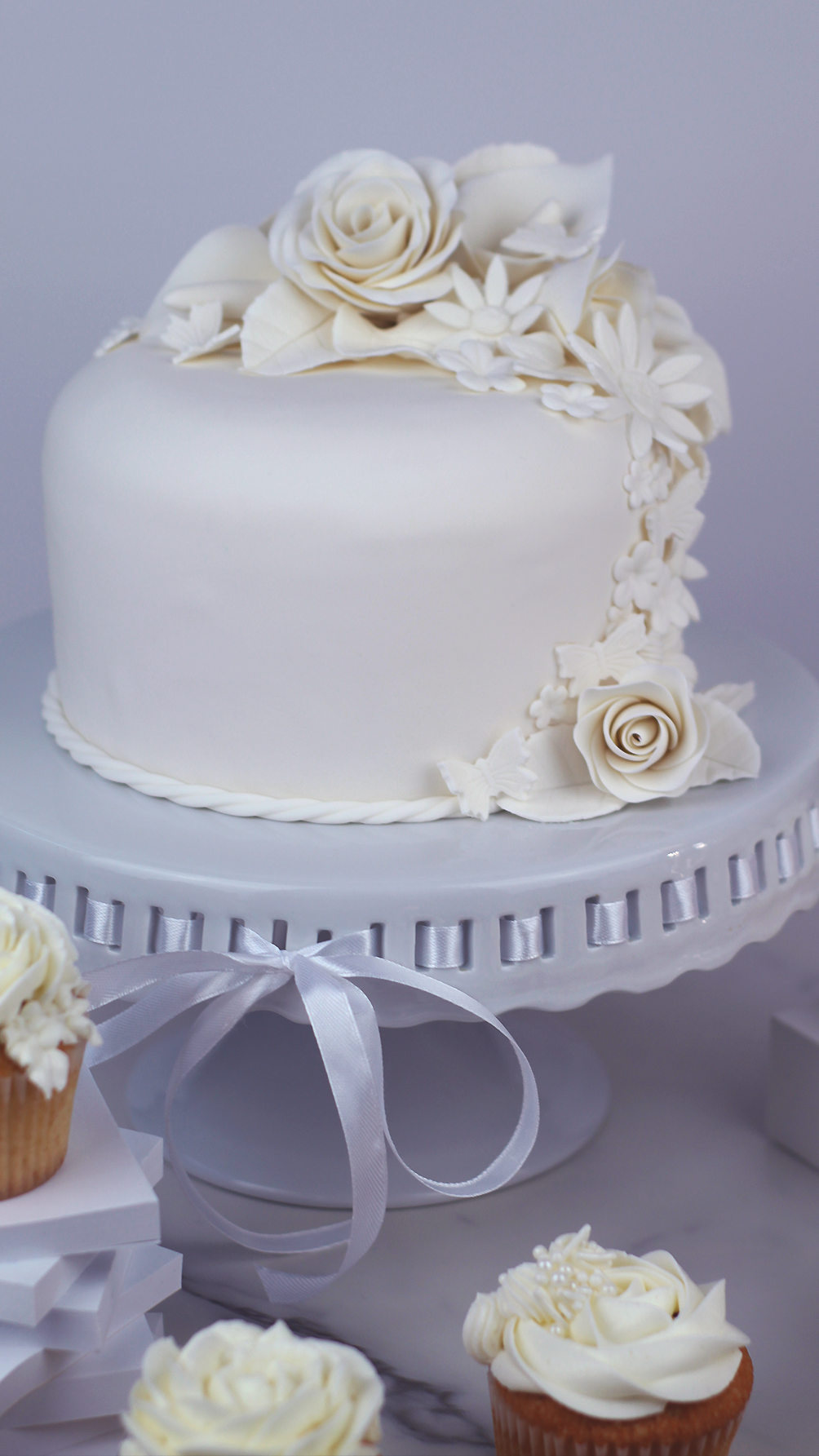 Pure white single tiered cake with cascading gum paste flowers